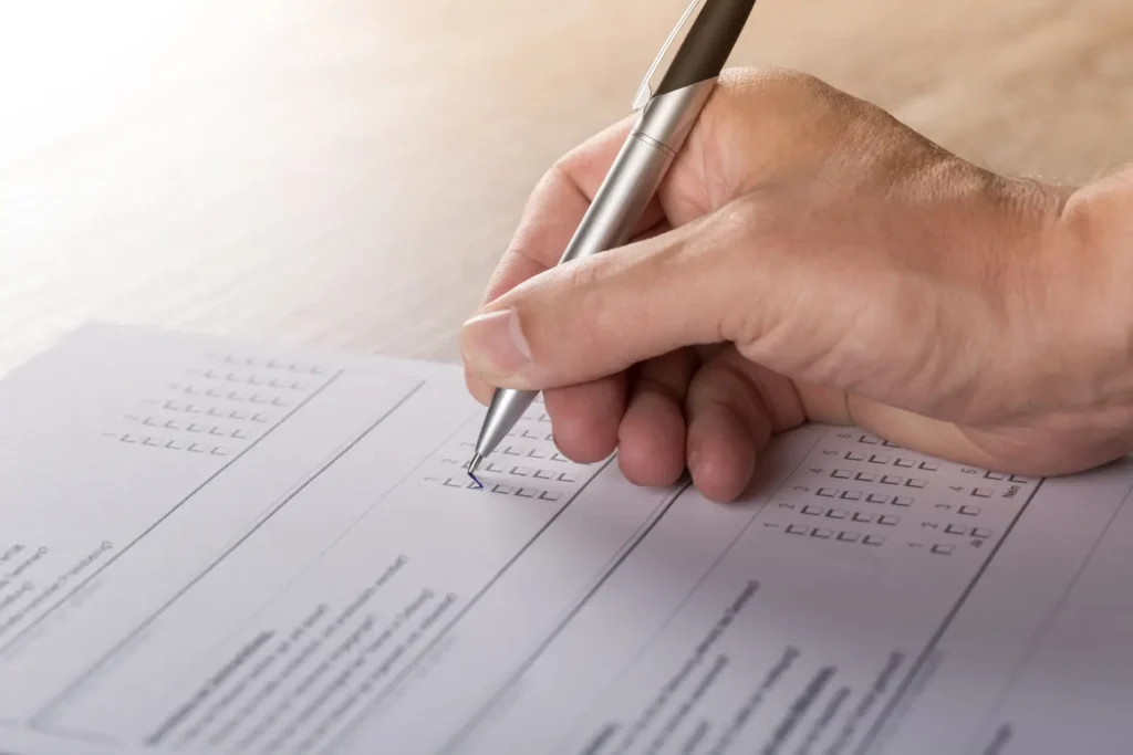 Immagine di una mano con una penna mentre compila un documento